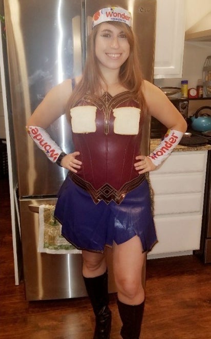 A woman in a wonder woman costume with wonder bread bags as arm hands and a headband
