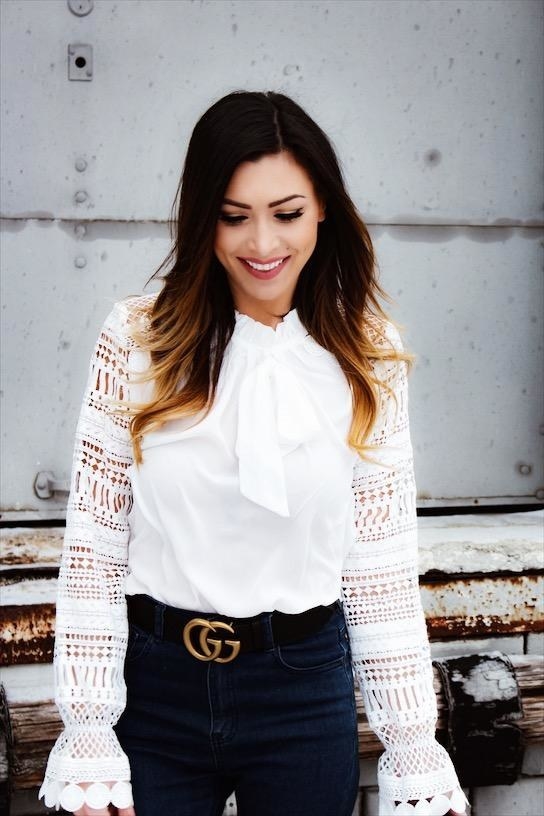 Reviewer wearing the blouse in white with a tie around the neck and lace sleeves with elastic near the end and flared hem. 