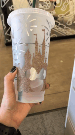 a gif of buzzfeed editor showing off their personalized rose gold castle cup