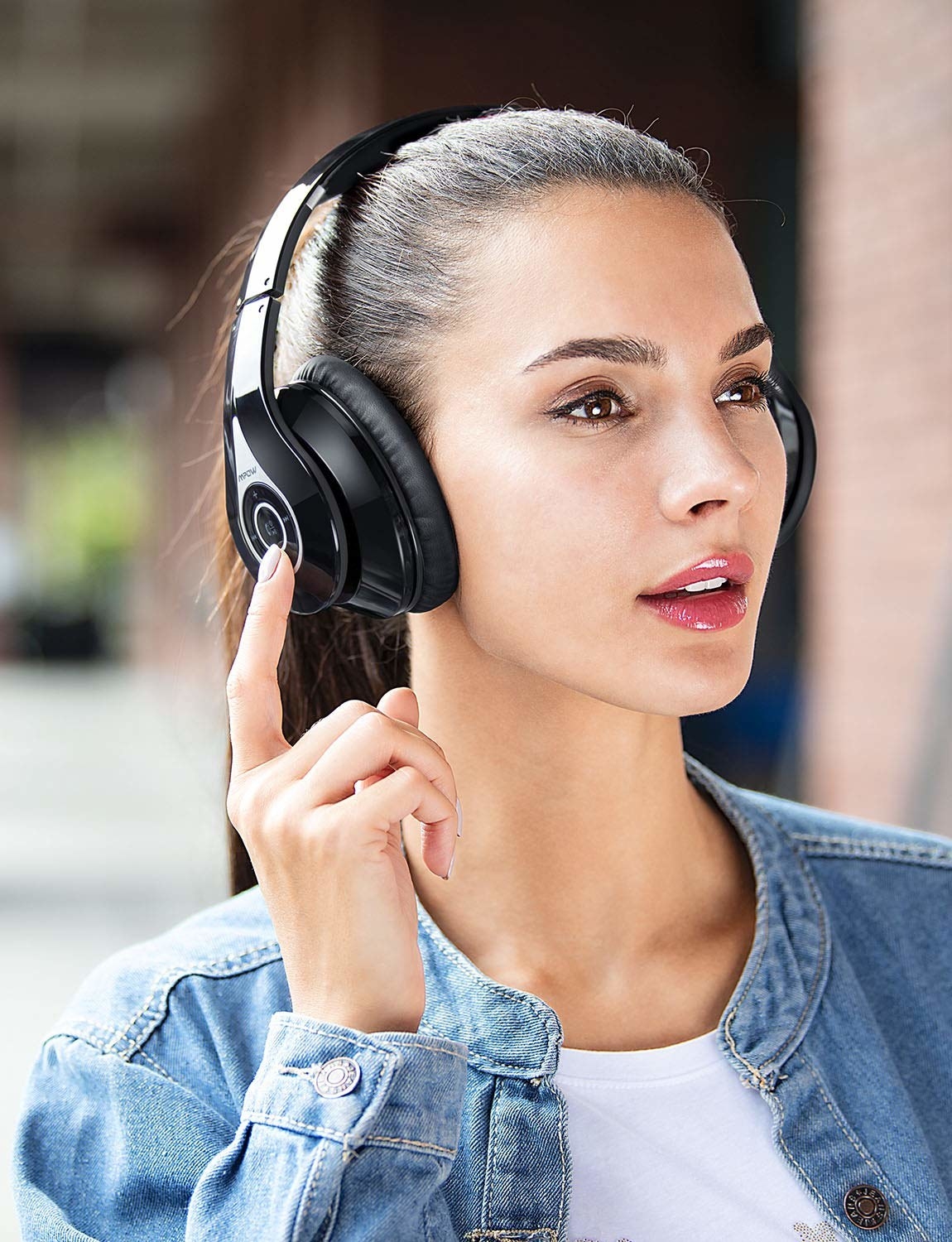 Model wears noise-isolating headphones in black