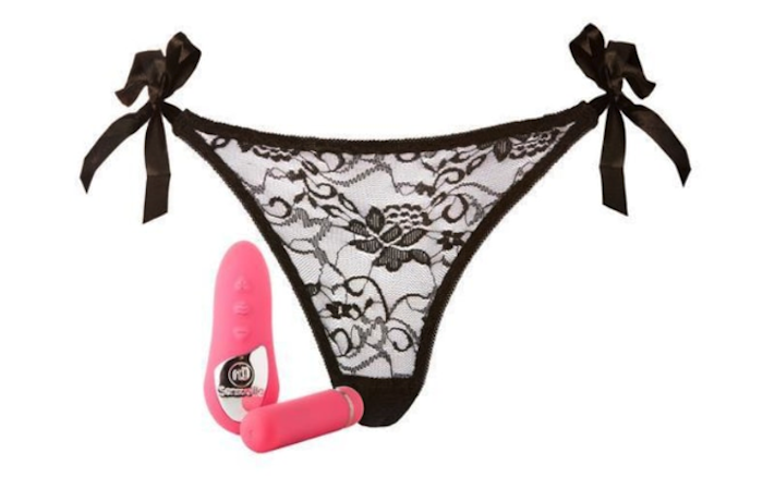 A black lace thong with the sides that tie into bows. The remote control and vibrator are sitting beside them.