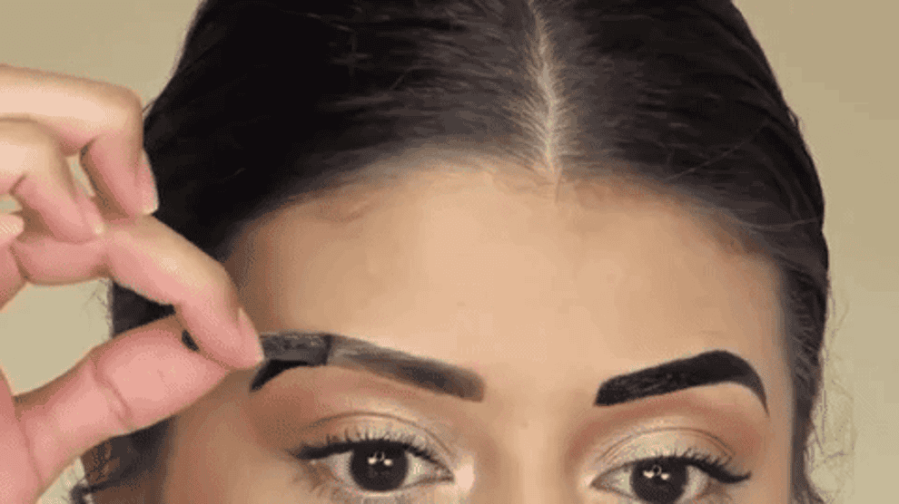 A person peeling the eyebrow gel off of their eyebrow