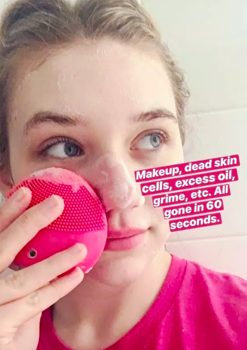 buzzfeed shopping editor washing her face with the device, with text that says &quot;makeup, dead skin cells, excess oil, grime, etc. All gone in 60 seconds.&quot; 