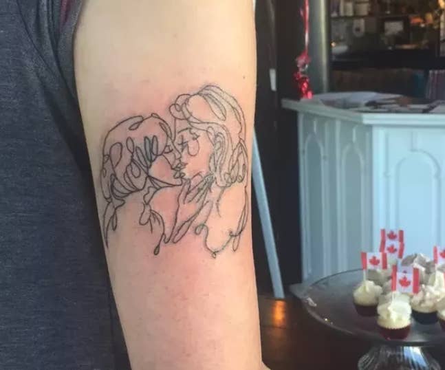 A tattoo of two women kissing on someone&#x27;s arm