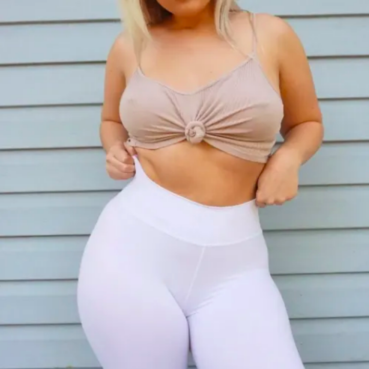 Person wearing leggings in white with tied bando top 