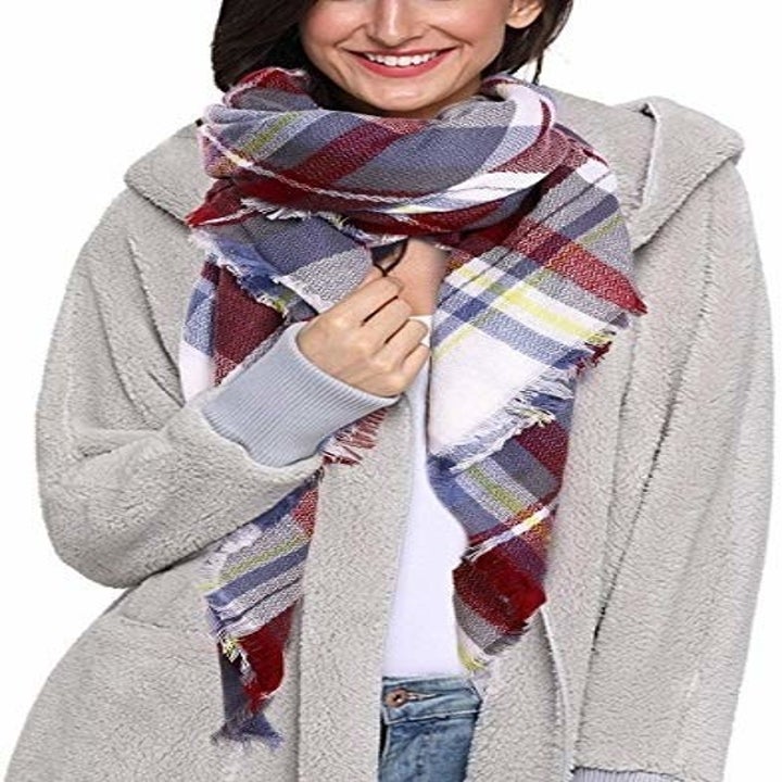 a model wearing the scarf in a blue, red, and white pattern