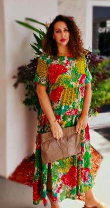 a reviewer in the t-shirt dress with a green red and yellow jungle pattern on it