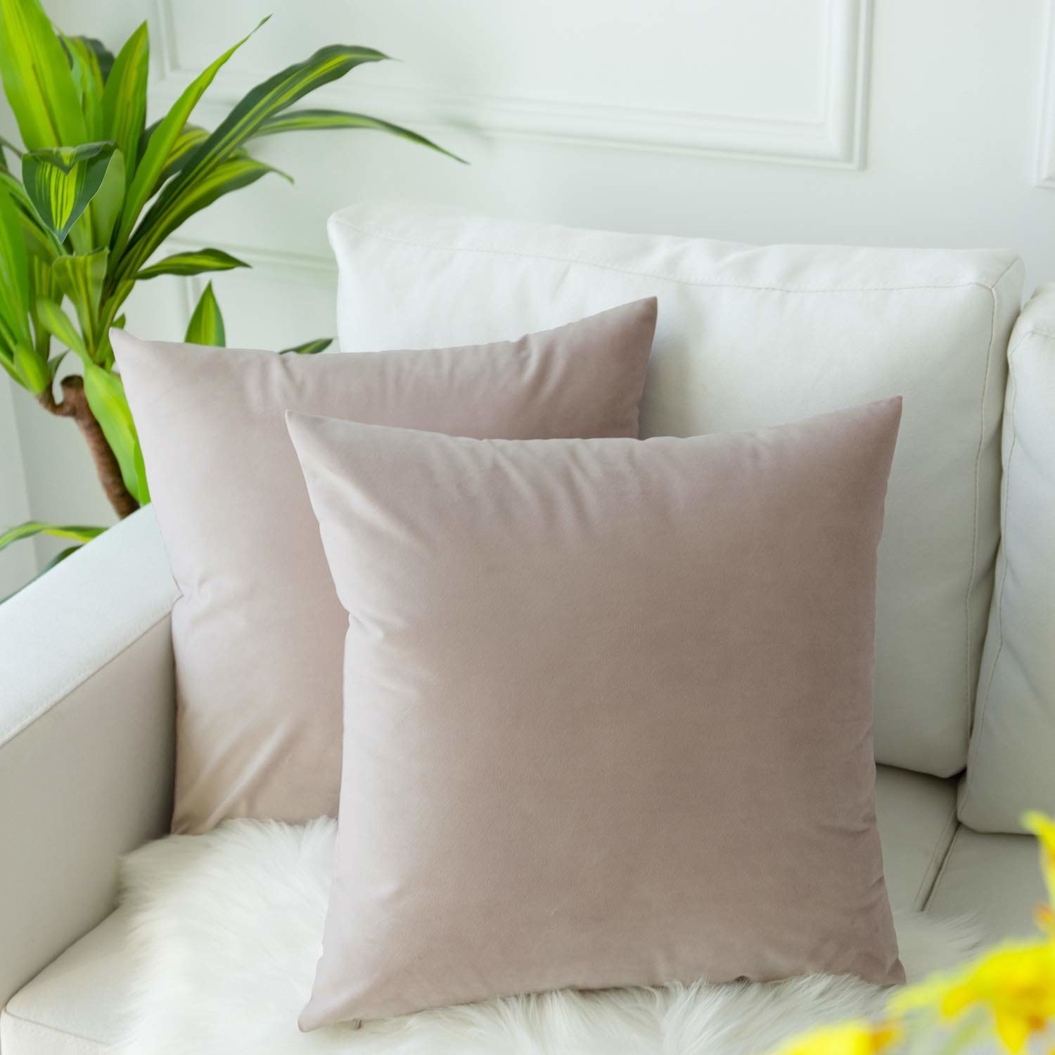 Two light pink velvet pillowcases on a couch