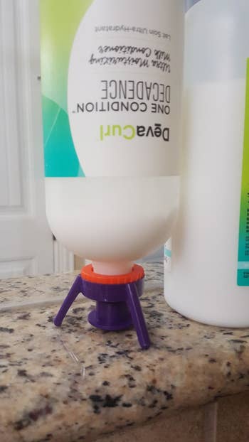 The tri-legged pop-top, screwed onto a conditioner pump bottle that's now turned upside down, and is balanced because of the top
