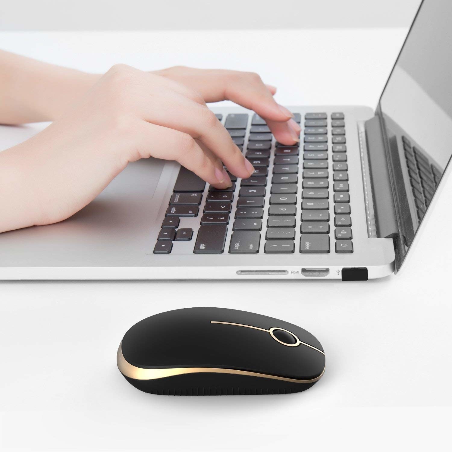 A laptop with a wireless mouse beside it