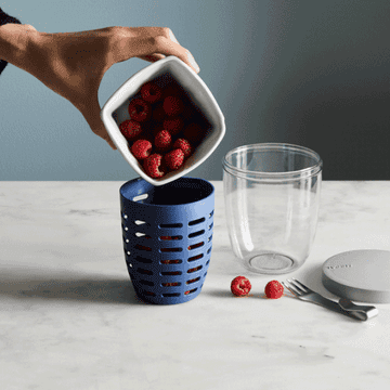 A gif of the container used as both a colander and cup