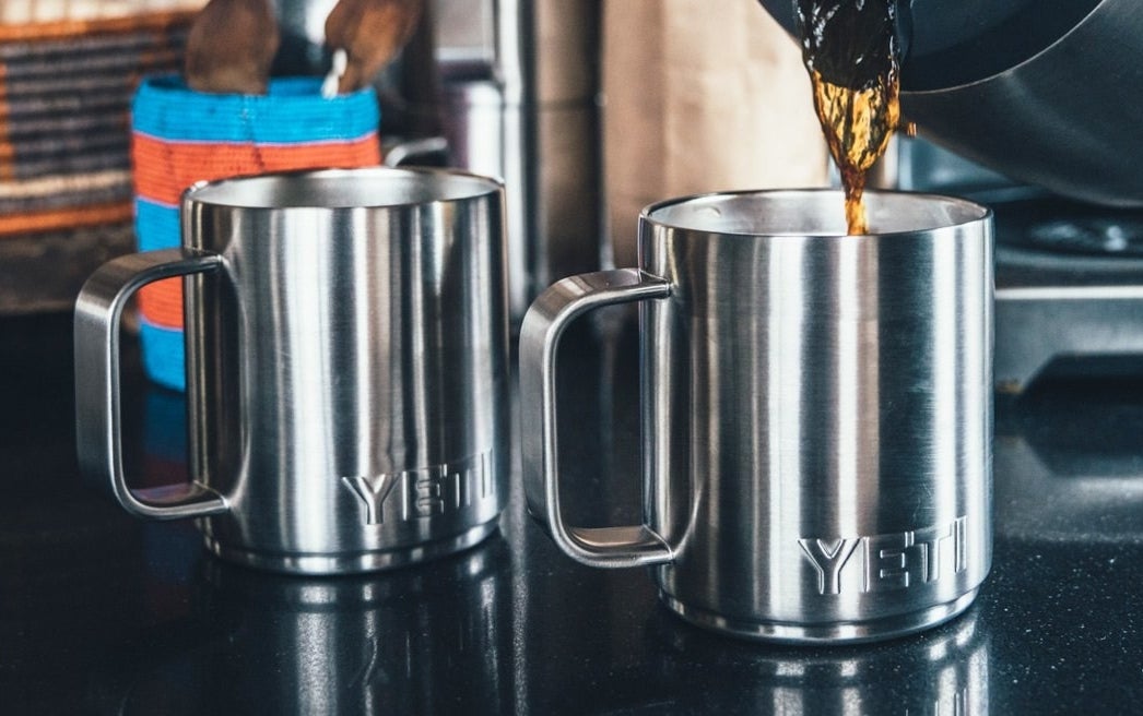 two stainless steel yeti mugs