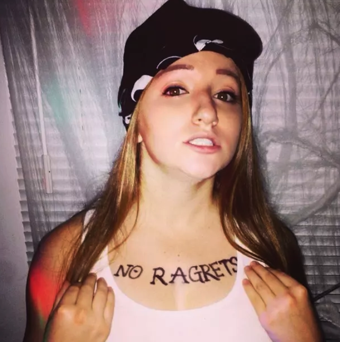 girl with the words &quot;No Ragrets&quot; drawn on her chest