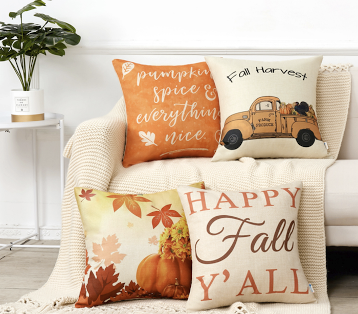 four fall pillows. one is orange and says &quot;pumpkin spice and everything nice.&quot; Another says, &quot;Fall Harvest&quot; and has a truck with fall produce on it. Another has pumpkins nad leaves on it. The last pillow says &quot;Happy Fall Y&#x27;all.&quot;