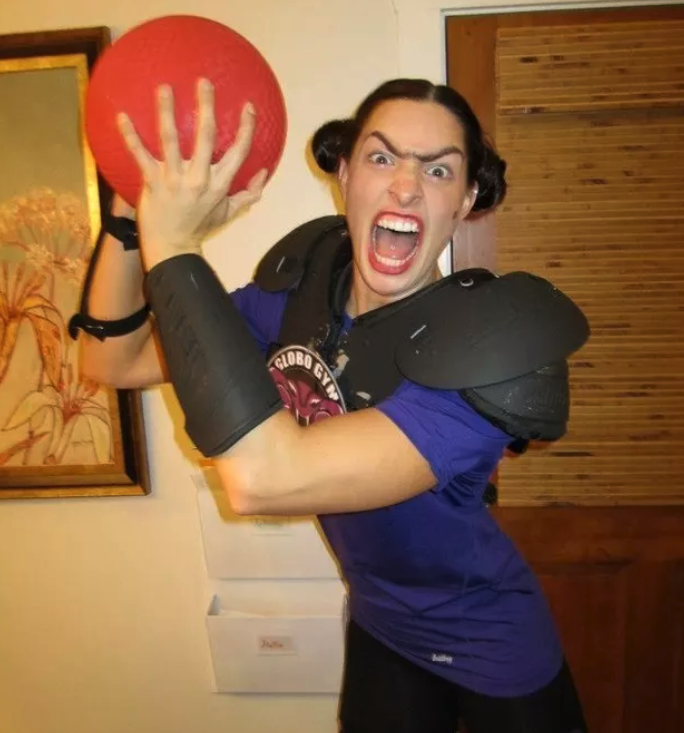 person holding a dodgeball wearing football padding