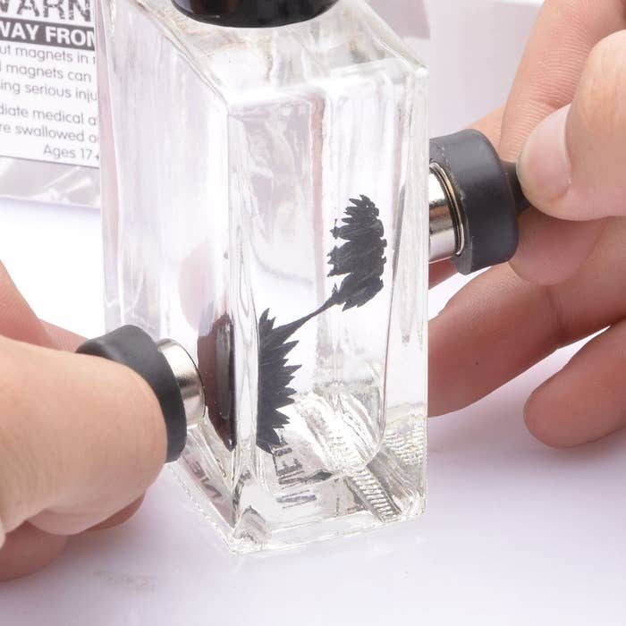 model uses magnets to make black liquid in glass bottle spiky 