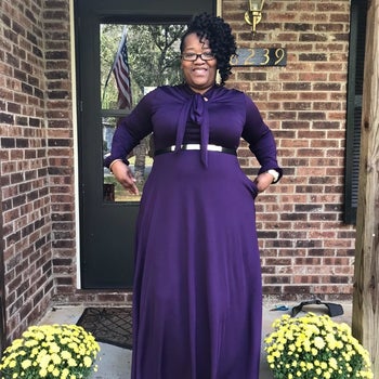 A different reviewer wearing the dress in purple with a belt