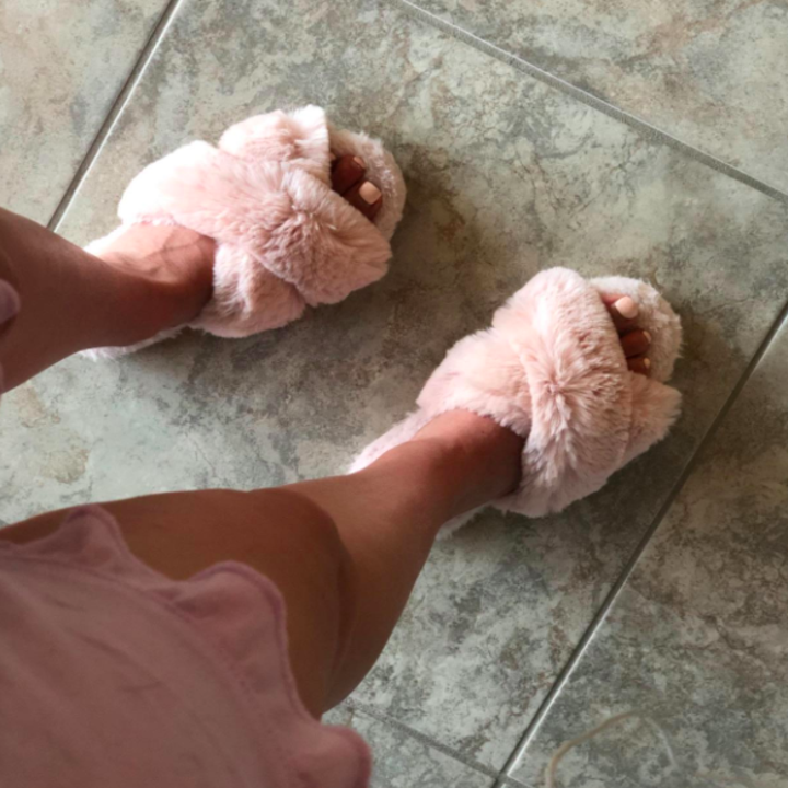 reviewer wearing pink version of the slippers