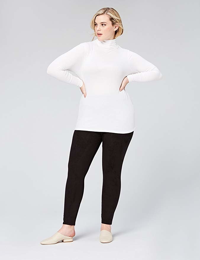 model wearing white turtle neck with black pants