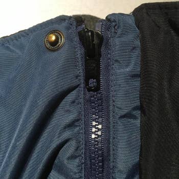a reviewer's coat with a repaired zipper