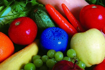 The Bluapple sitting in a pile of fresh produce