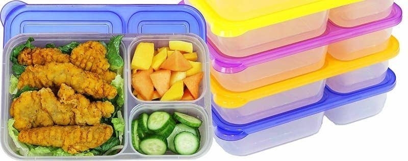 The bento boxes with one filled with chicken in the big compartment, and fruit and veggies in the two smaller compartments