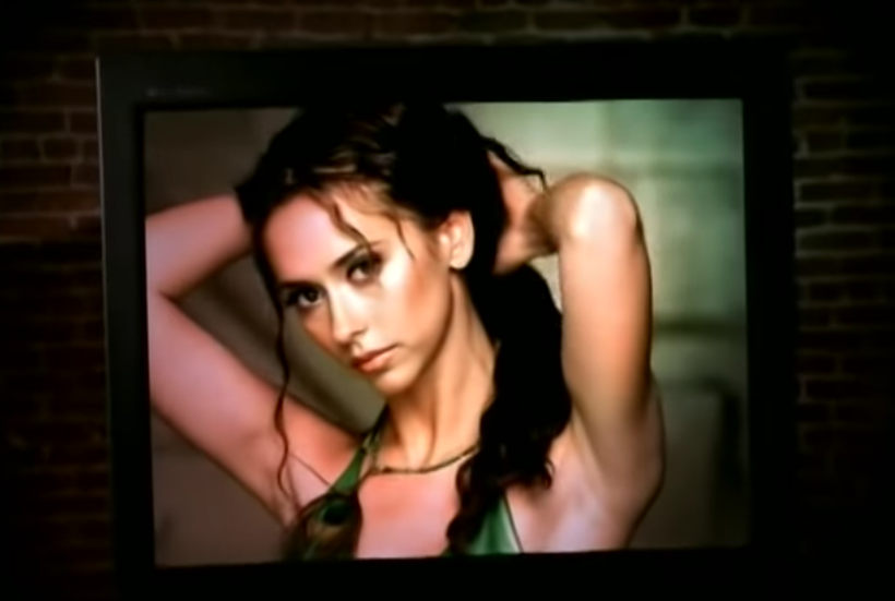 A screenshot of Jennifer lifting her hair back
