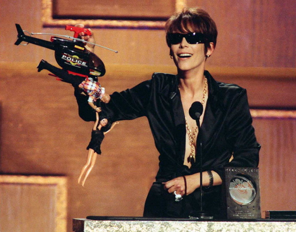 Jamie holding a toy helicopter as two Barbie dolls hang from it