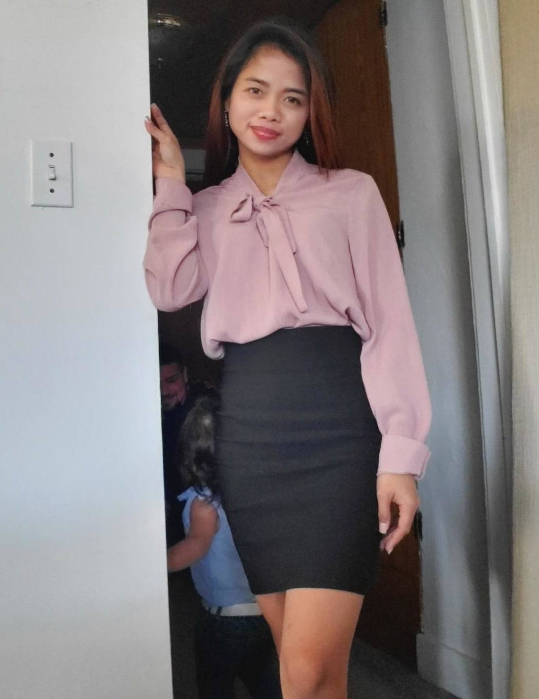 reviewer wearing the top in blush with a pencil skirt 