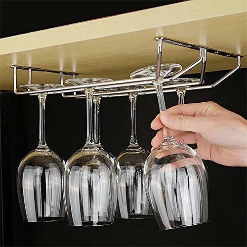The glass holder attached under a shelf with wine glasses hanging upside down from it.