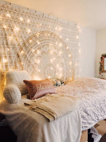 The string lights draped down a wall by a bed