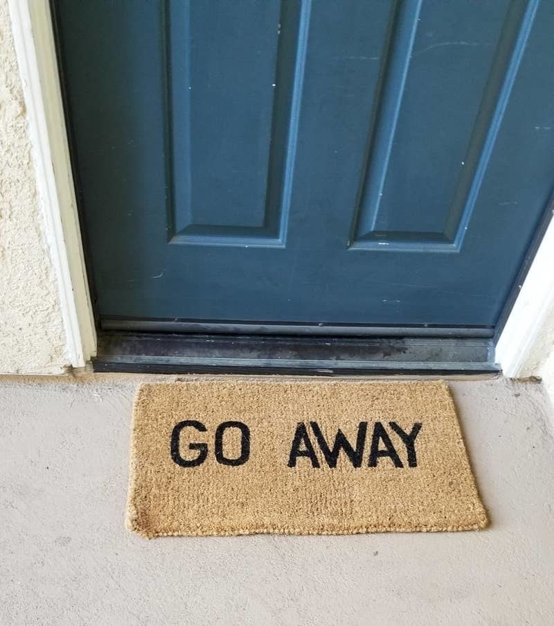 Reviewer pic of a brown doormat with the words &quot;Go Away&quot; written on it