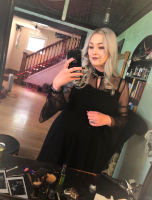 reviewer wearing black dress with mesh bell sleeves