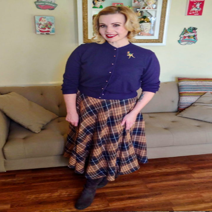 A reviewer wearing the brown and blue plaid skirt