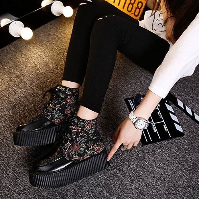 A model wearing the ankle sneakers, which have a large platform and floral print