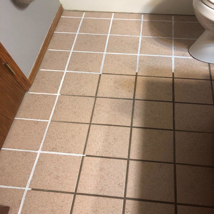 Reviewer photo where you can clearly see the clean white grout they've painted compared to the dirty brown grout