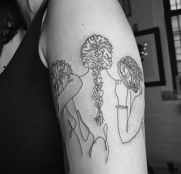 A tattoo of three women with their backs to the camera