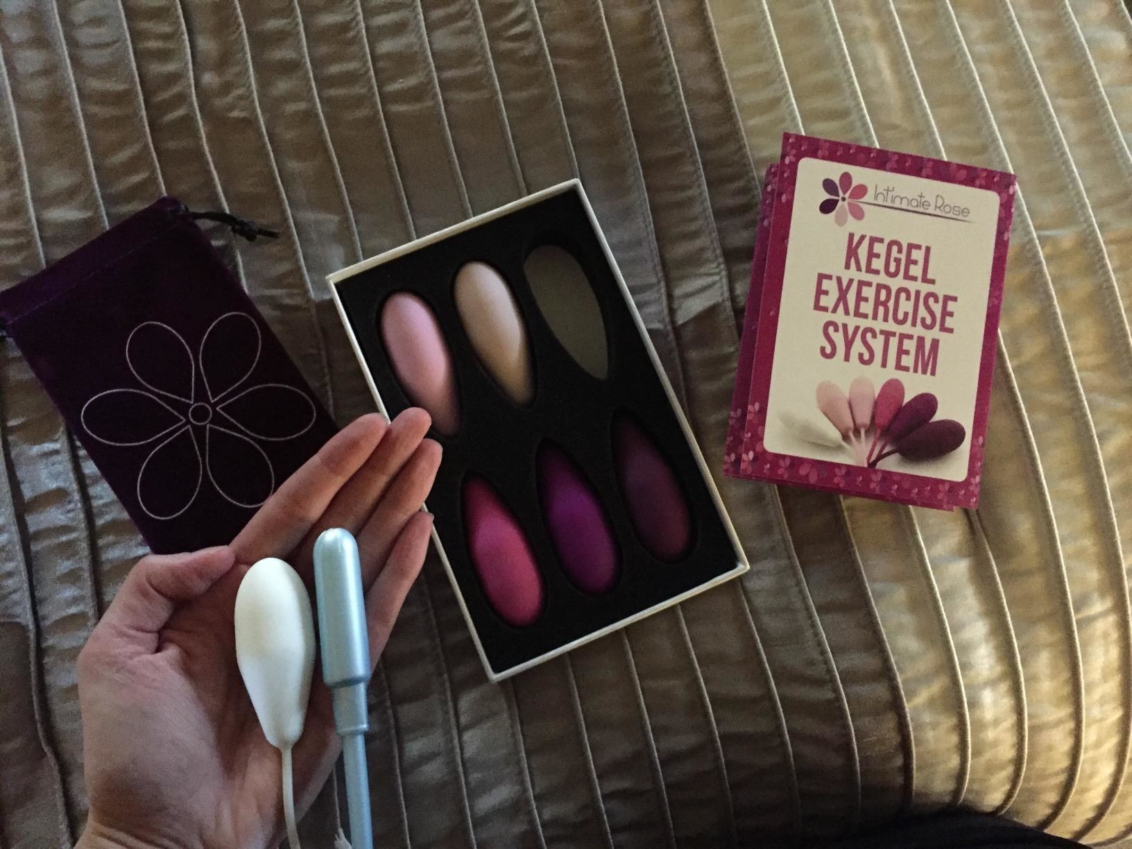 Reviewer holding one of the weights and a tampon in the same hand to show they&#x27;re similar in size