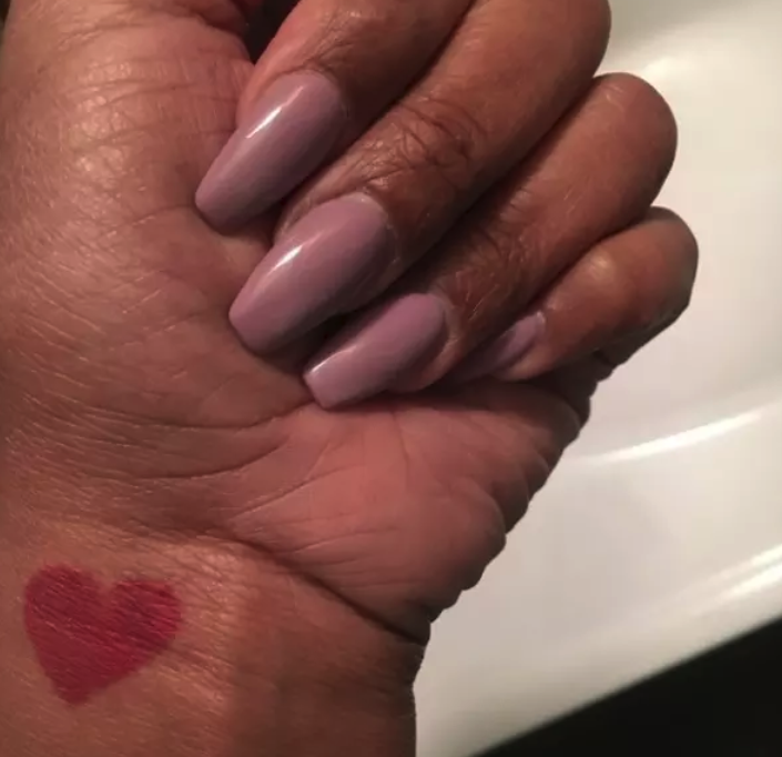 A tiny tattoo of a red heart on someone's wrist