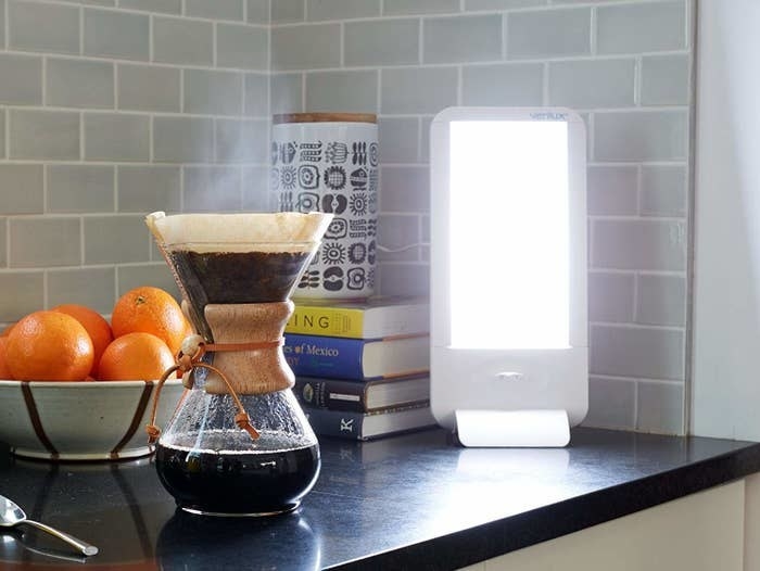 The rectangle-shaped light sitting on the counter with a pour-over coffee next to it