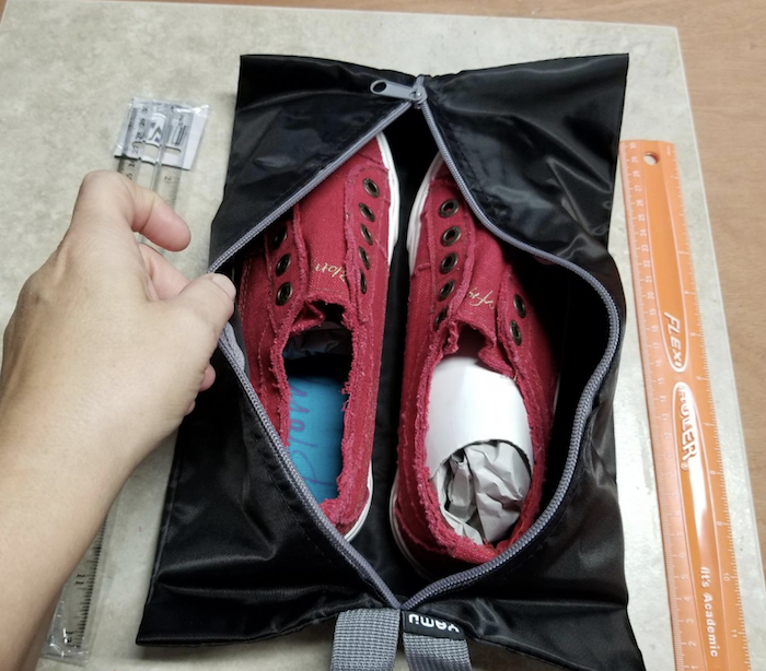 A reviewer&#x27;s pair of sneakers inside the travel bag 