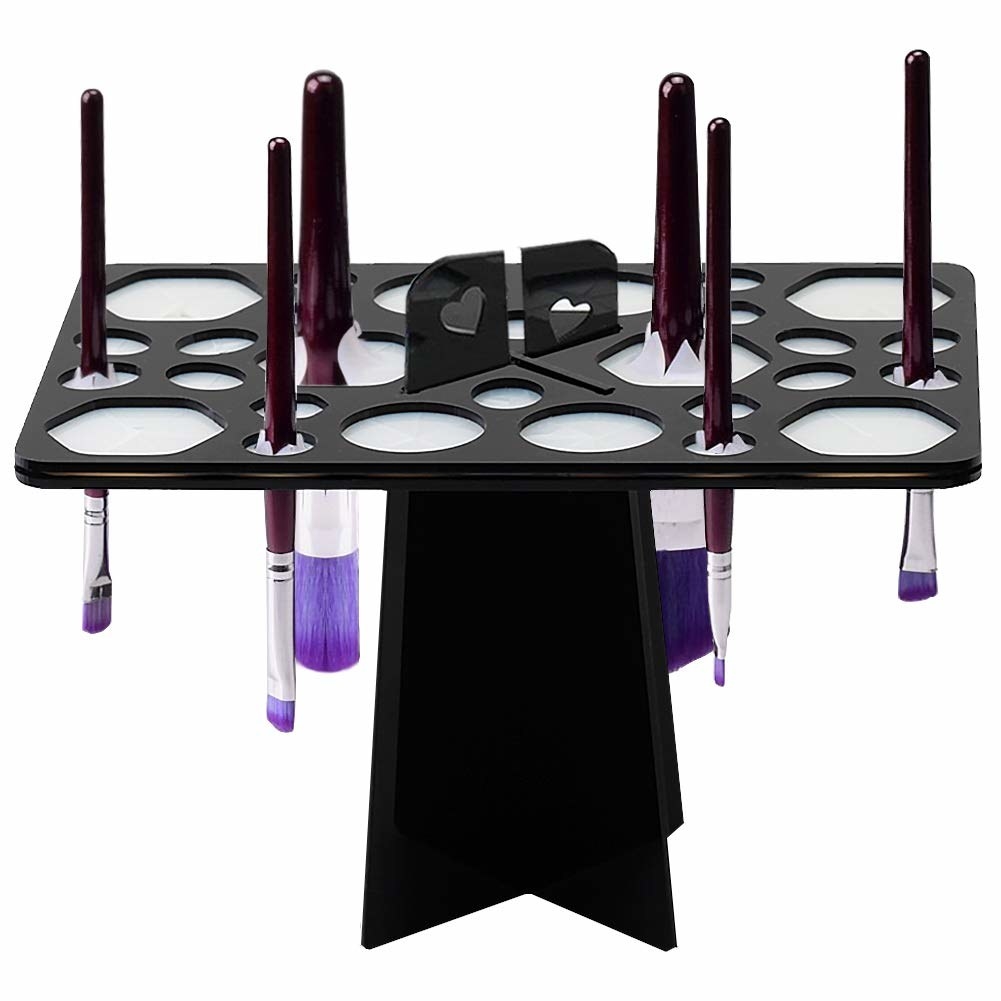 A T-shaped drying rack with makeup brushes held upside down in small circular holes