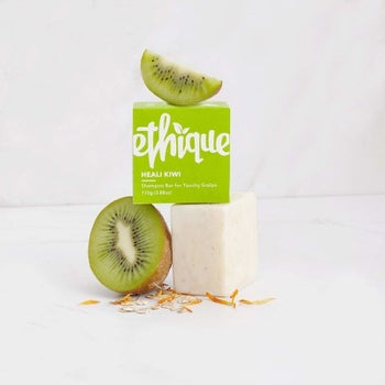 white shampoo bar with the green packaging on the top with kiwis on top and next to it