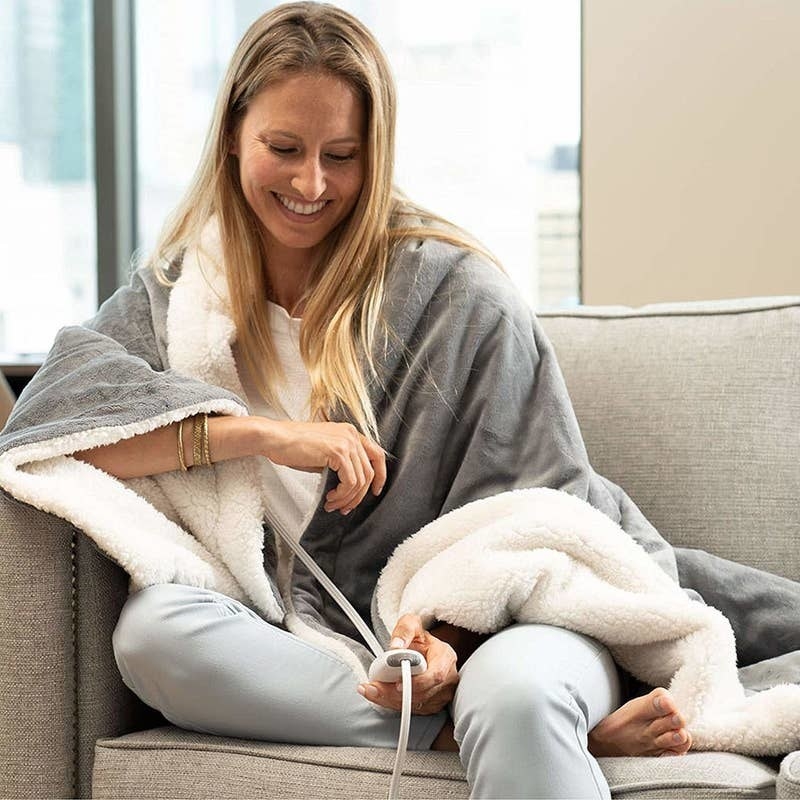 model wrapped in grey microfiber and white shearling heated blanket