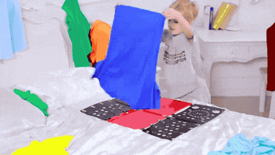 gif of child folding shirt with board