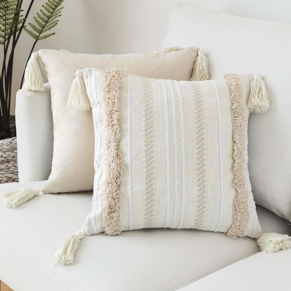 the off white and tan pillows with tassels