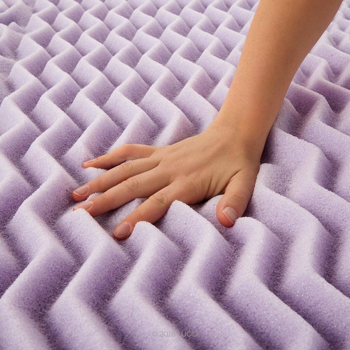 a hand squishing onto the purple chevron-like topper