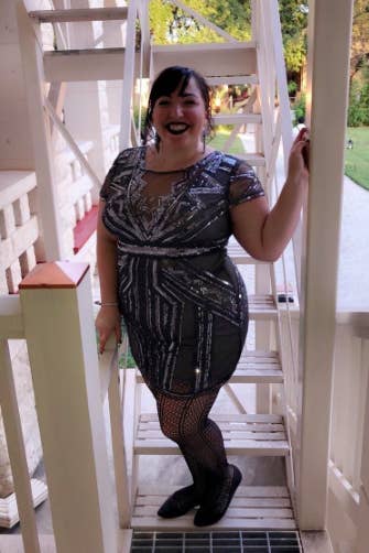 A reviewer wearing the above-the-knee dress in gray with silver beading