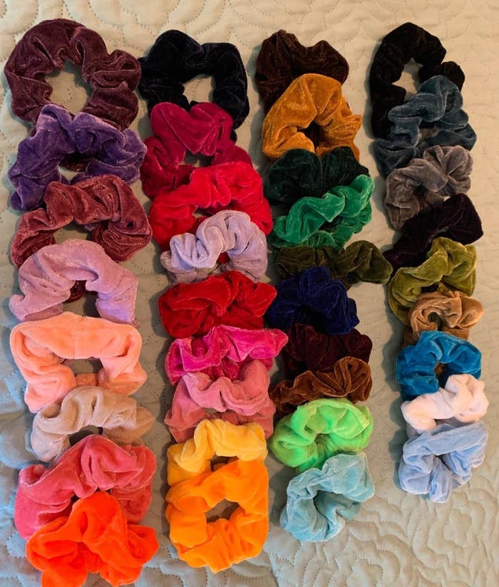 reviewer showing the pack of scrunchies in multiple colors laid out