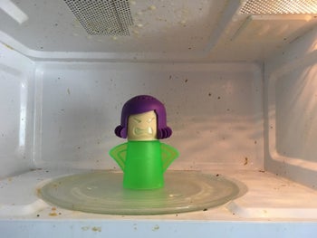 The human-shaped steam cleaner in a dirty microwave